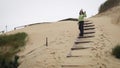 Tourist girl at wooden pathway at Curonian Spit sand dunes Royalty Free Stock Photo