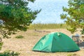 Tourist green tent on the lake.