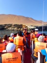 Tourist group in a boat near Candelabra of the Andes in Pisco Ba