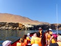 Tourist group in a boat near Candelabra of the Andes in Pisco Ba