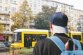 A tourist in a baseball cap with a backpack on Berlin Street in Germany.