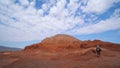 A tourist guy walks in a canyon of unusual red rocks