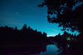 Tourist have a rest in his camp near the forest at night. Man under beautiful night sky full of stars and enjoying night scene Royalty Free Stock Photo