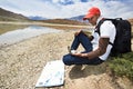 Tourist hiker with compass and map in mountains Royalty Free Stock Photo