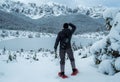 Tourist hiker with crampons looking at mountains in snow. Royalty Free Stock Photo