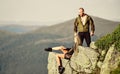 Tourist hiker girl and man relaxing. Hiking benefits. Hiking weekend. On edge of world. Woman sit edge of cliff high Royalty Free Stock Photo