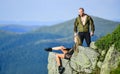 Tourist hiker girl and man relaxing. Hiking benefits. Hiking weekend. On edge of world. Woman sit edge of cliff high Royalty Free Stock Photo