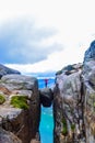 The tourist hiker girl standing on top of Kjeragbolten - the most dangerous stone in the world. Norway Royalty Free Stock Photo