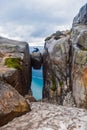 The tourist hiker man sitting on top of Kjeragbolten - the most dangerous stone in the world. Norway Royalty Free Stock Photo