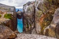 The tourist hiker man take a selfie while sitting on top of Kjeragbolten - the most dangerous stone in the world. Norway Royalty Free Stock Photo