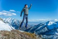 Tourist hikers in the high jump in the background of snowy mountains. Concept of adventure, freedom and active lifestyle Royalty Free Stock Photo