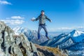 Tourist hikers in the high jump in the background of snowy mountains. Concept of adventure, freedom and active lifestyle Royalty Free Stock Photo