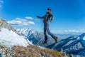 Tourist hikers in the high jump in the background of snowy mountains. Concept of adventure, freedom and active lifestyle Royalty Free Stock Photo