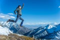 Tourist hikers in the high jump in the background of snowy mountains. Concept of adventure, freedom and active lifestyle Royalty Free Stock Photo