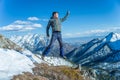 Tourist hikers in the high jump in the background of snowy mountains. Concept of adventure, freedom and active lifestyle Royalty Free Stock Photo