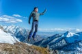 Tourist hikers in the high jump in the background of snowy mountains. Concept of adventure, freedom and active lifestyle Royalty Free Stock Photo