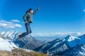 Tourist hikers in the high jump in the background of snowy mountains. Concept of adventure, freedom and active lifestyle Royalty Free Stock Photo