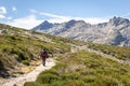 Tourist hiking on a trail to the Laguna Grande de Gredos, Sierra de Gredos mountains, Spain