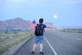 Tourist hitchhiking along a desolate road Royalty Free Stock Photo