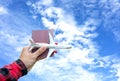 Tourist holding airplane flight travel and passport traveller fly travelling citizenship air on blue sky background. Royalty Free Stock Photo