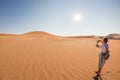 Tourist holding smart phone and taking photo at scenic sand dunes at Sossusvlei, Namib desert, Namib Naukluft National Park Royalty Free Stock Photo