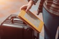 Tourist holding travel suitcase and passport. Generate ai