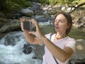 Tourist holds in hand a smartphone Woman cell phone on a journey. Photographing a landscape