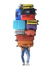 A tourist holds a huge pile of suitcases