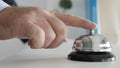 Tourist in Hotel Reception Presses the Bell Button Calling the Receptionist