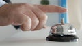 Tourist in Hotel Reception Presses the Bell Button Calling the Receptionist