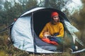 Tourist hugging red shiba inu in camp tent on background froggy rain forest, hiker woman with puppy dog in mist nature trip Royalty Free Stock Photo