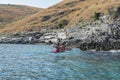 Tourist kayaking at Himara rocky shore