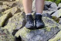 Tourist legs in trekking boots. Hike. Mountains and rocks.