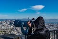 A tourist while looking at the Point of view telescope at Viewpoint Twin Peaks San Francisco, California USA, March 30, 2020 Royalty Free Stock Photo