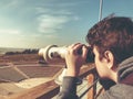 Tourist looks in the binoculars tower viewer at the city view. Tower viewer is a popular device for looking at the city.