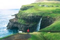 Tourist looks at the Mulafossur waterfall near Gasadalur on Faroe Islands Royalty Free Stock Photo