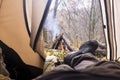 Tourist lying in tent and looking at the fire in the mountain forest Royalty Free Stock Photo