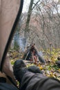 Tourist lying in tent and looking at the fire in the mountain forest Royalty Free Stock Photo