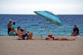 Tourist lying under a colorful beach umbrella on Dania Beach