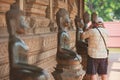 Tourist makes photo of the Buddha statue outside of Hor Phra Keo temple in Vientiane, Laos.