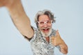 Tourist makes selfie. Senior stylish modern man with grey hair and beard indoors