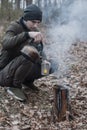 Tourist makes tea in the forest on a Swedish candle,