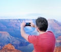 Tourist making mobile photo of the famous Grand Canyon