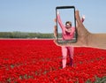 Tourist making photo of womanin tulip field Royalty Free Stock Photo