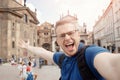 Tourist Male student smiles and shoots blog on selfie camera, Prague, Czech Republic, Charles Bridge