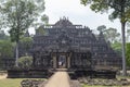 Tourist man in Angkor Wat temple ruin. Ancient temple Baphuon stone ruin in green tropical landscape.