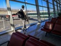 A tourist man with a backpack and a passport in his hand looks at the runway at the Esenboga International Airport. A man is