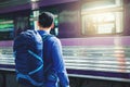 Tourist man backpacker using map to travel at train station Royalty Free Stock Photo