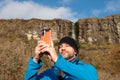 Tourist man enjoys view of Devil`s chimney waterfall, county Sligo, Ireland. Warm sunny day, Cloudy sky. Travel and outdoor