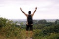 Tourist man with hands raised up and looking beautiful view feeling happy and smiling at nature,Back view